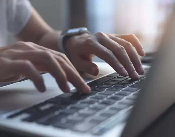 Hands typing on computer